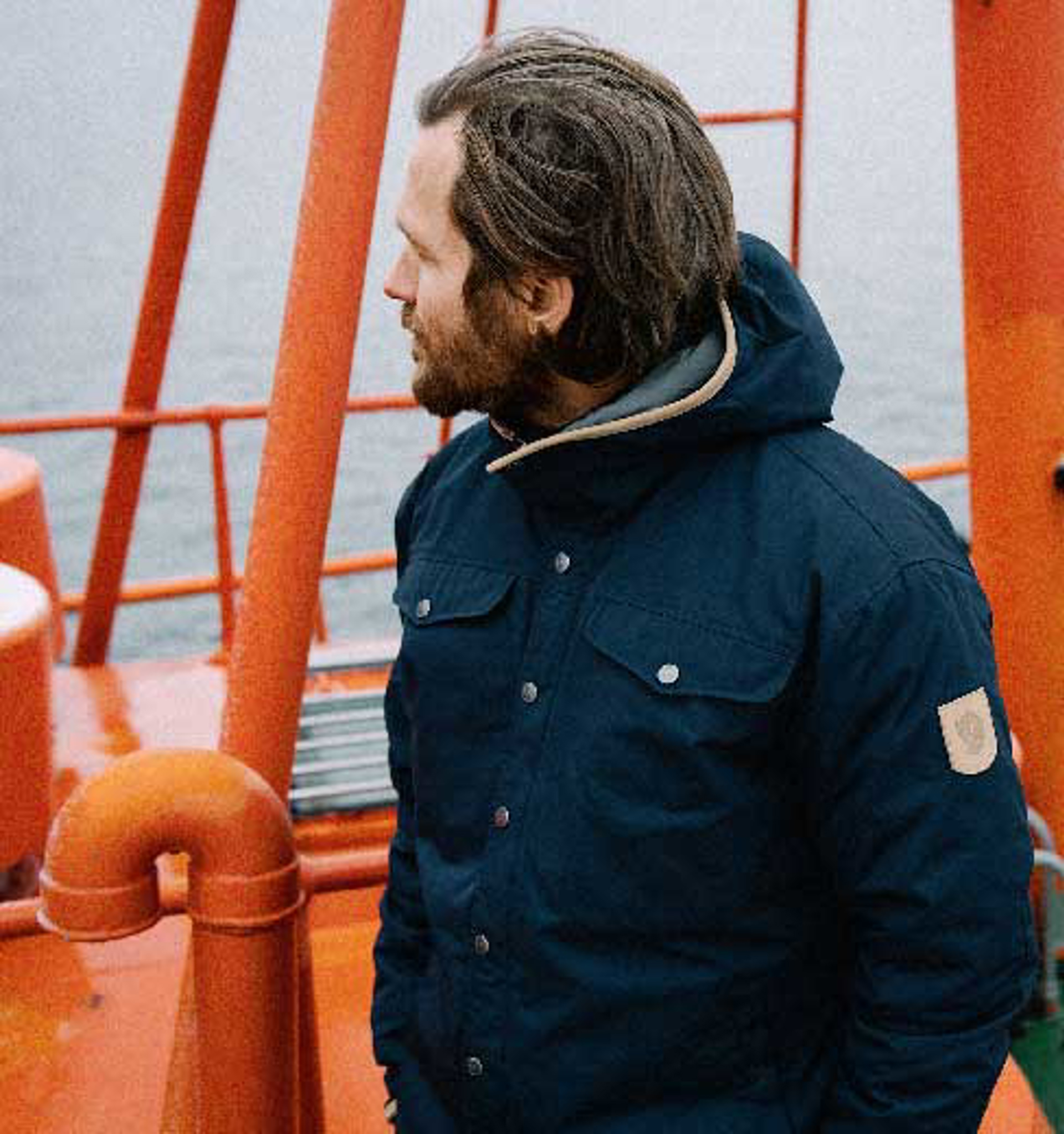 a man wearing a Fjallraven Greenland jacket standing by a bouy